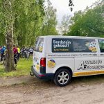 VW Transporter auf MSR Verpflegungsstation mit pausierenden Radlern im Hintergrund